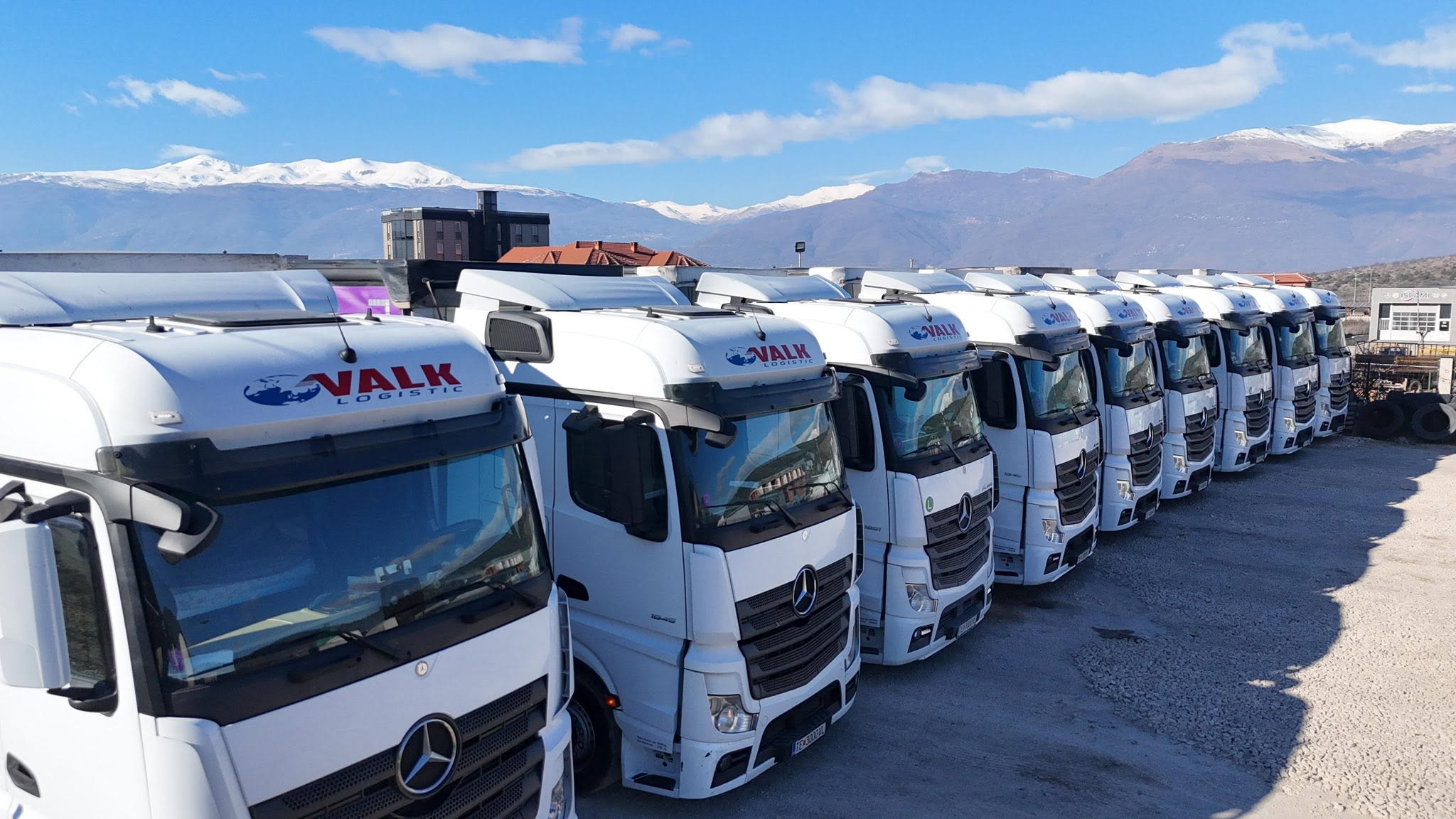 VALK Logistic trucks lined up with mountains in the background